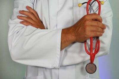 Doctor wearing a white coat holding equipment