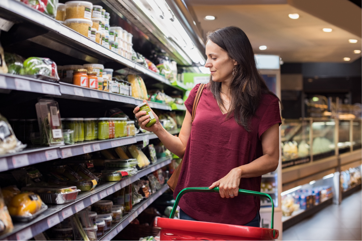 A Caucasian woman reading a food label in a supermarket