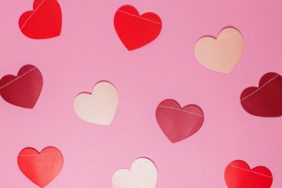A flatlay of pink, red and white paper hearts for Valentine's Day