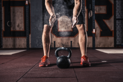 person in gym working out with kettlebell